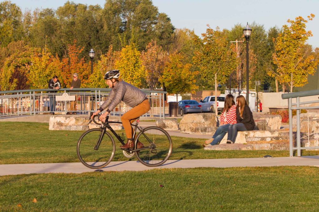 A person riding a bike on a bike path in a park